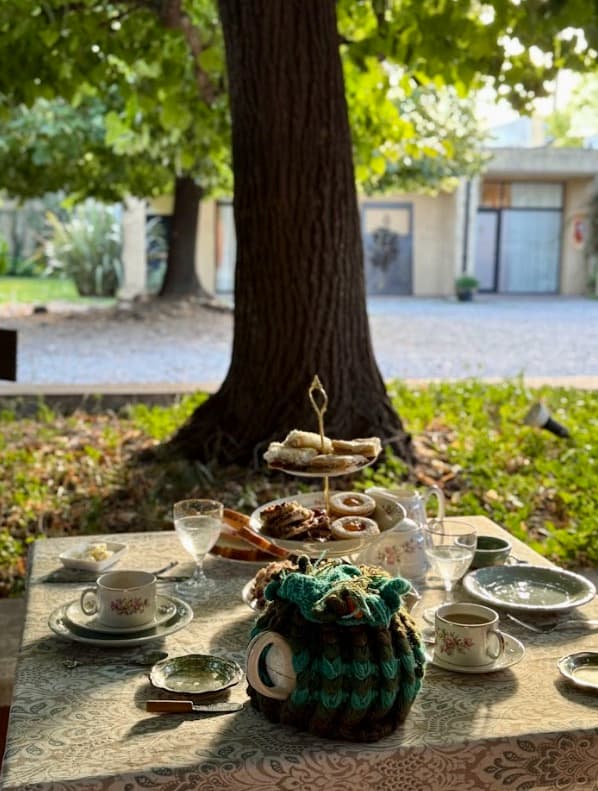 Mesa de té servida bajo los tilos en La Posada del Té